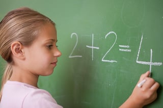 Schoolgirl writing a number on a blackboard.jpeg